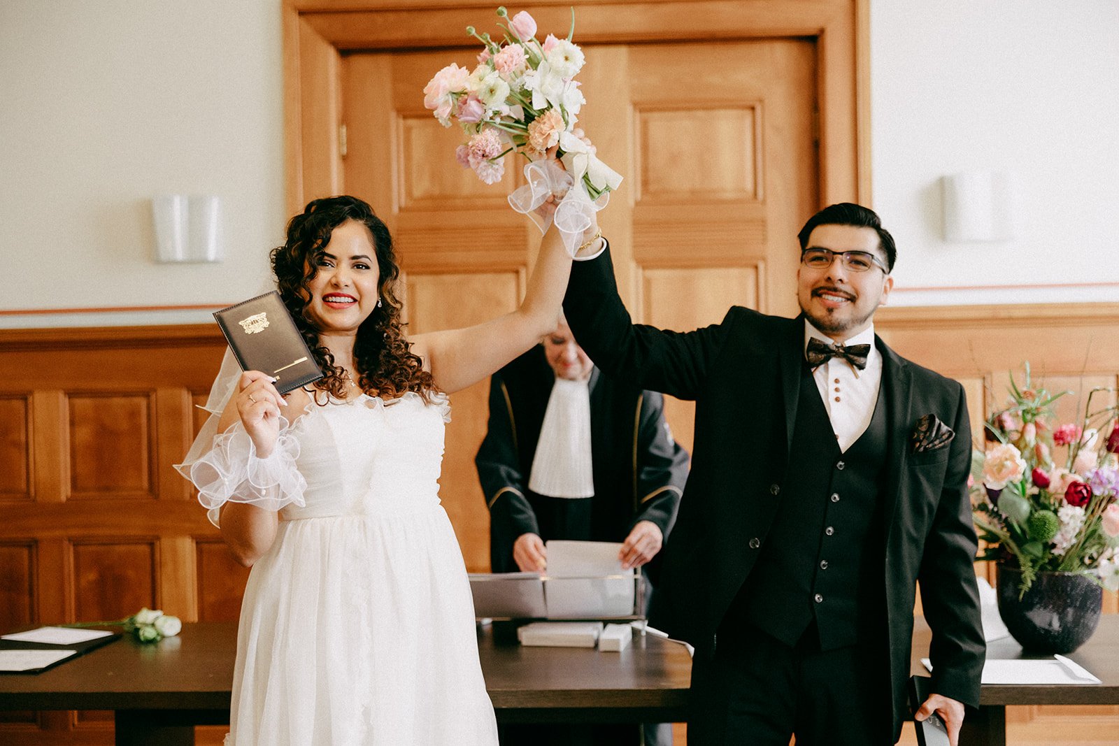 Happy couple holding official marriage documents after legal wedding registration at the Amsterdam gemeente