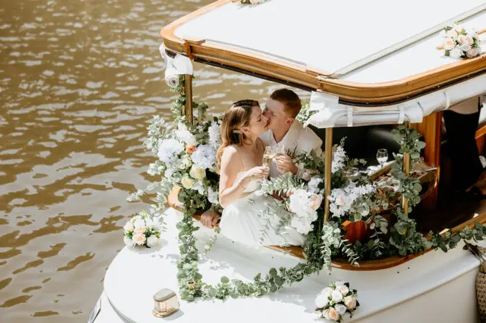 Couple kissing on a flower-styled canal boat during an intimate Amsterdam elopement