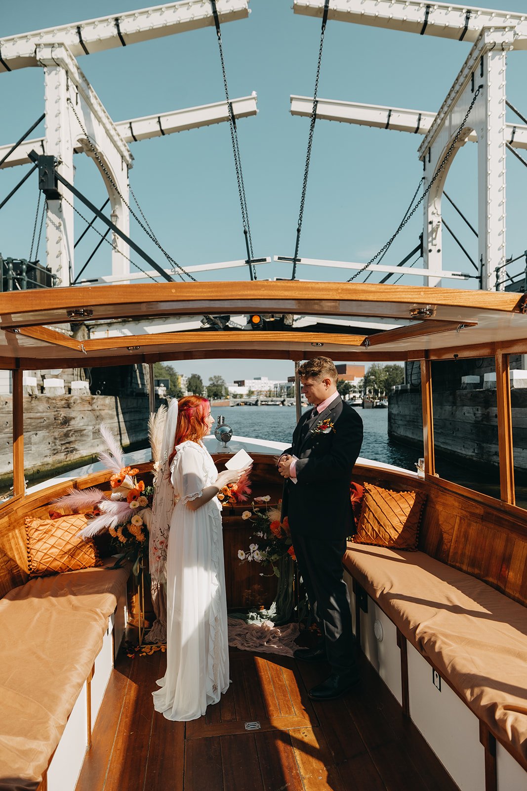 Couple exchanging vows during a private boat elopement ceremony with Skinny Bridge in the background
