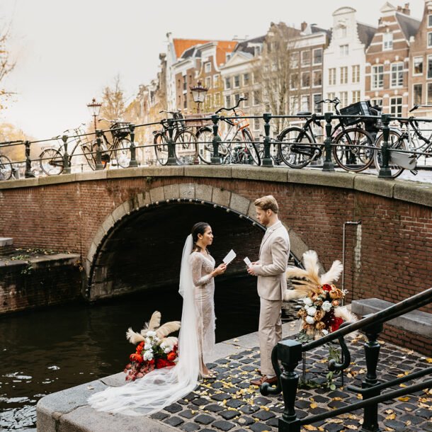 Bridal couple standing on a quiet pier during their elopement in Amsterdam ceremony