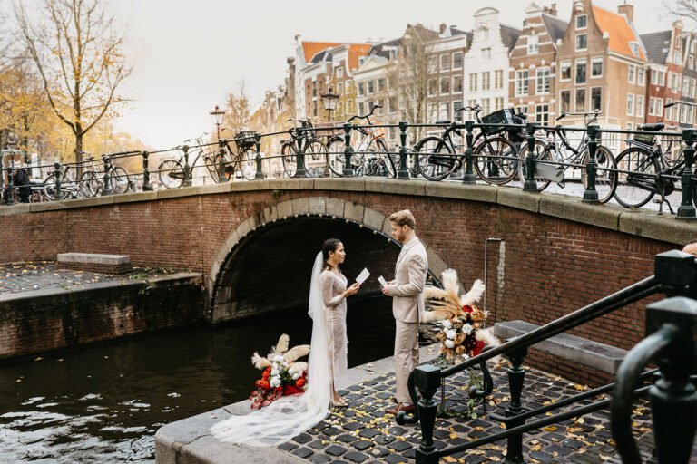 Bridal couple standing on a quiet pier during their elopement in Amsterdam ceremony