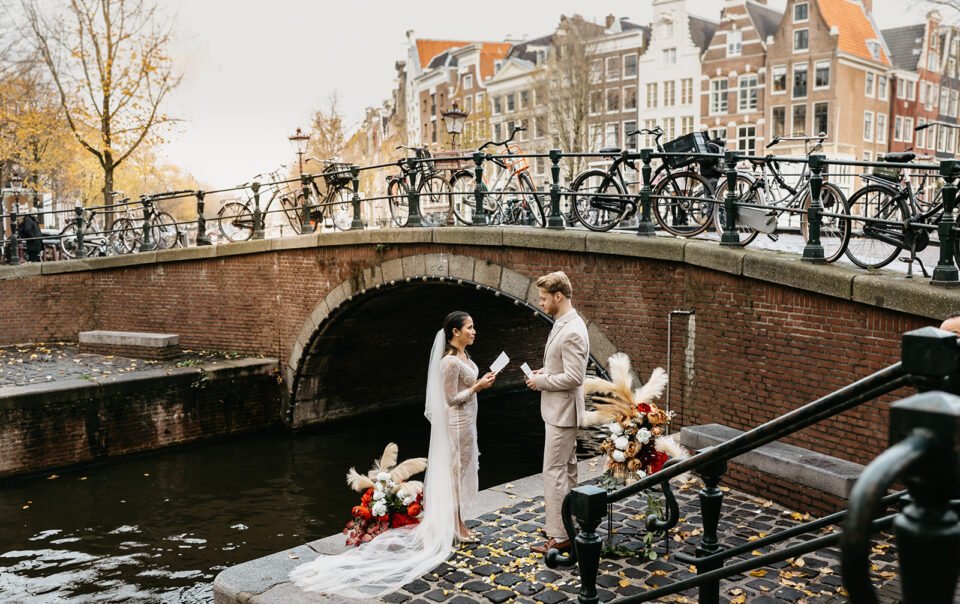 Bridal couple standing on a quiet pier during their elopement in Amsterdam ceremony