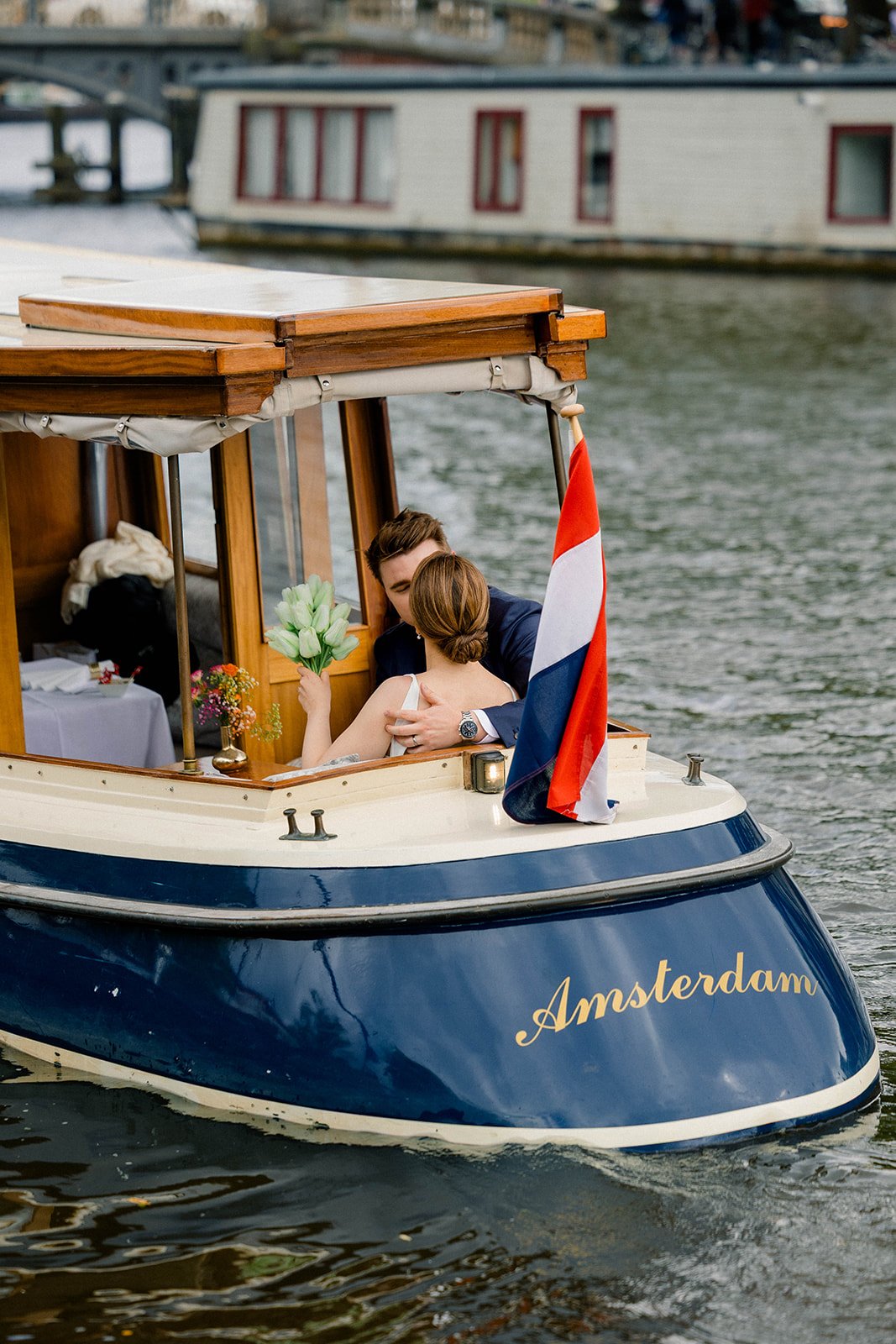 Couple kissing while sitting on a boat during a canal cruise in Amsterdam