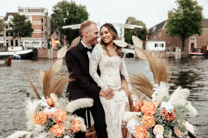 Couple sitting on a decorated canal boat during a romantic Amsterdam elopement experience