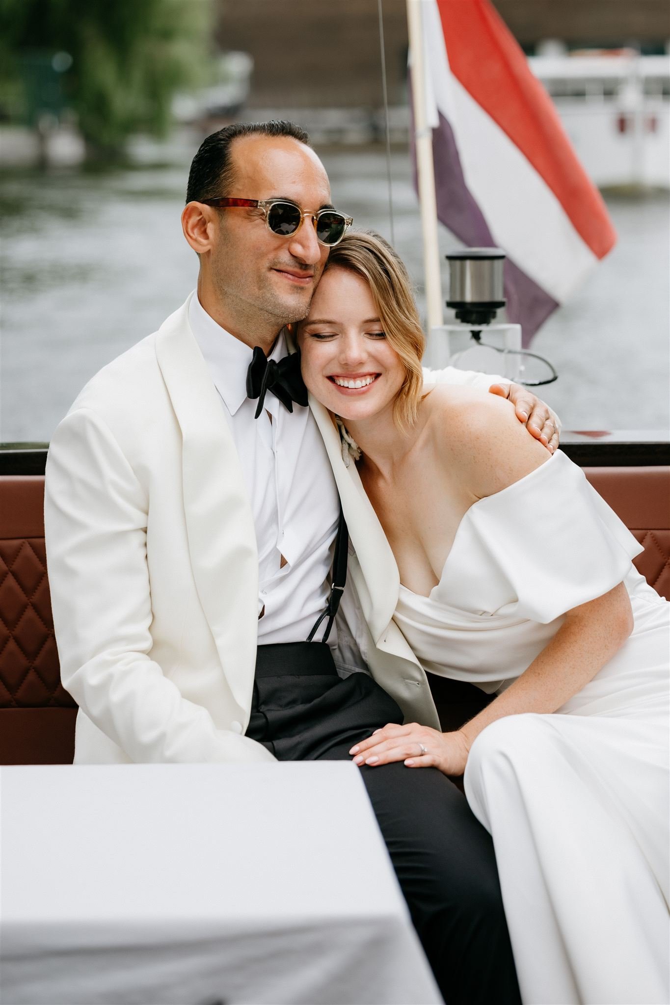 Bridal couple smiling and hugging during a photoshoot in Amsterdam