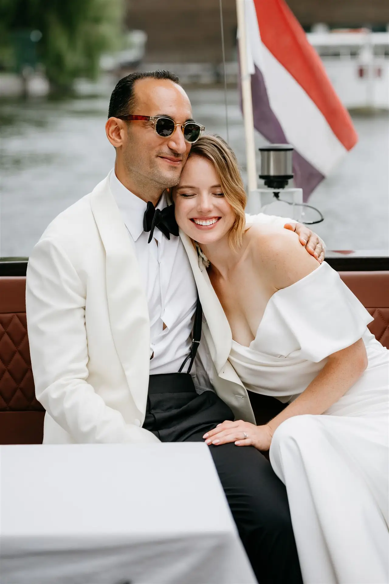 Bridal couple smiling and hugging during a photoshoot in Amsterdam