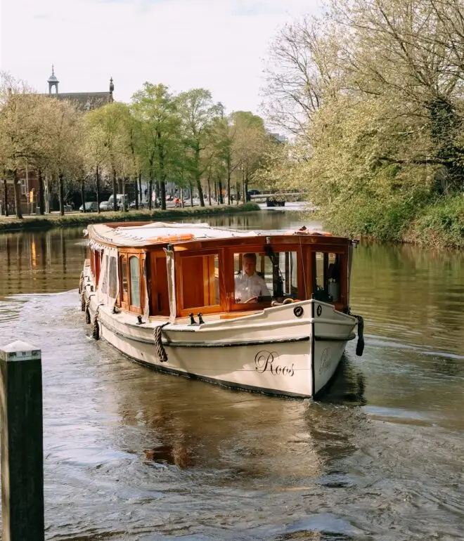 Classic canal boat cruising through Amsterdam canals during a private boat elopement