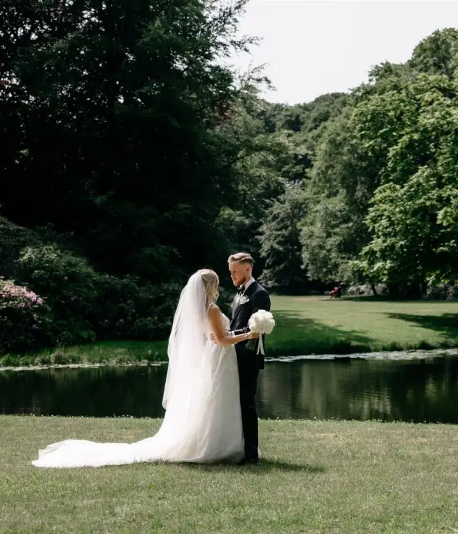 Couple standing by a lake in a green park during an intimate elopement in Amsterdam