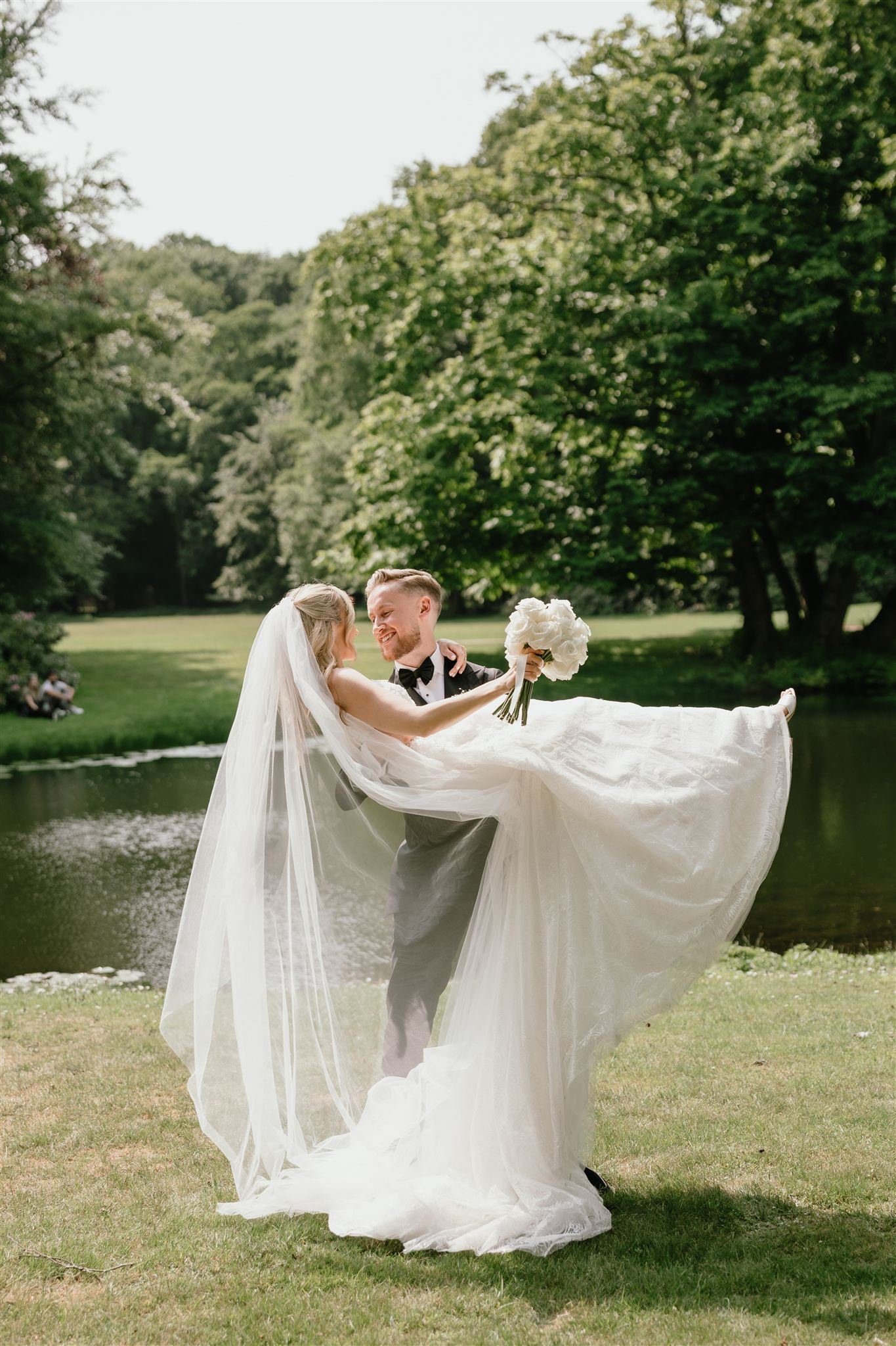 Groom carrying his bride in his arms during a park elopement ceremony