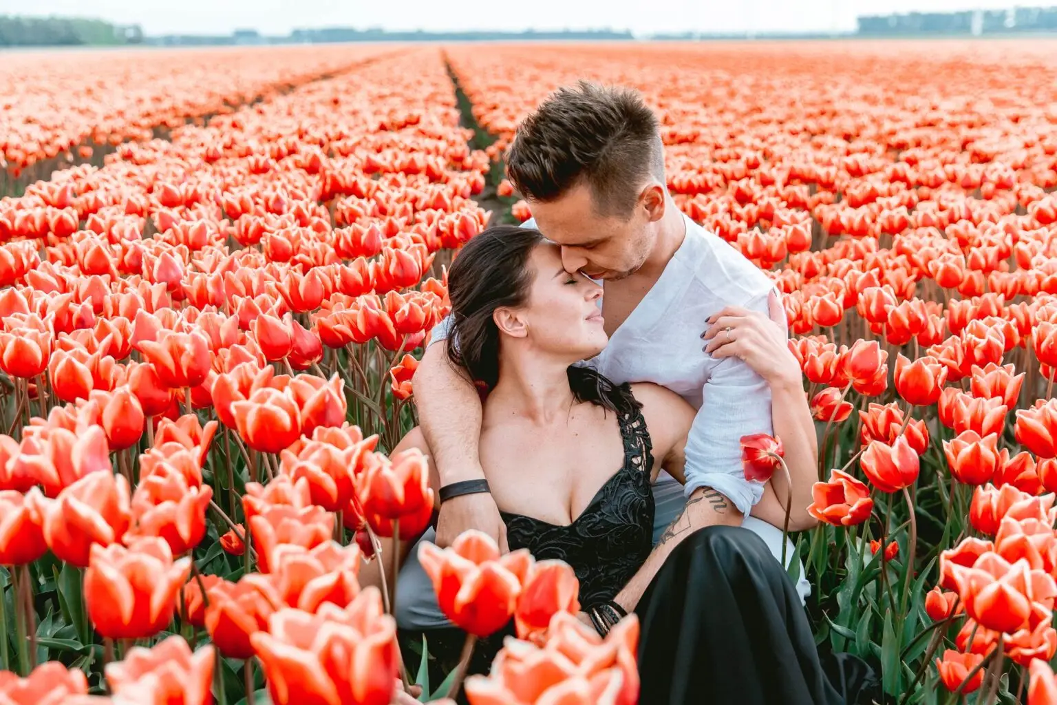 Couple embracing in blooming tulip fields near Amsterdam during spring elopement season