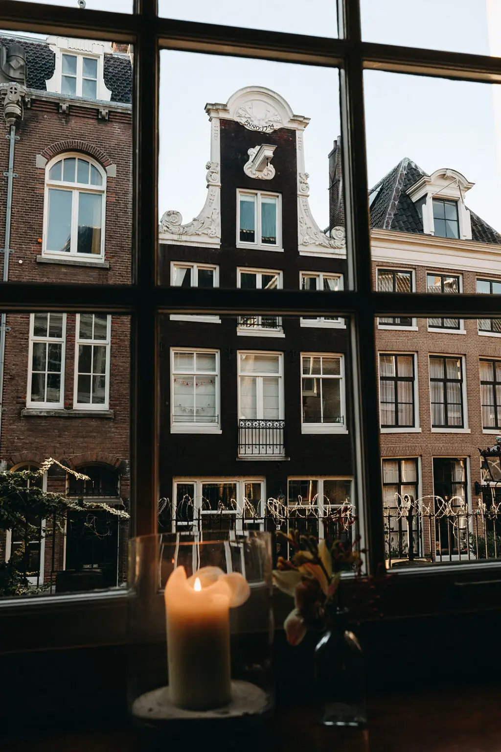 View of historic canal houses through a window during an intimate indoor elopement in Amsterdam