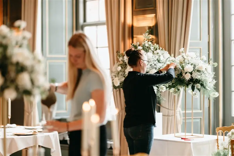 Wedding florist preparing large floral arrangements inside an elegant Amsterdam elopement venue
