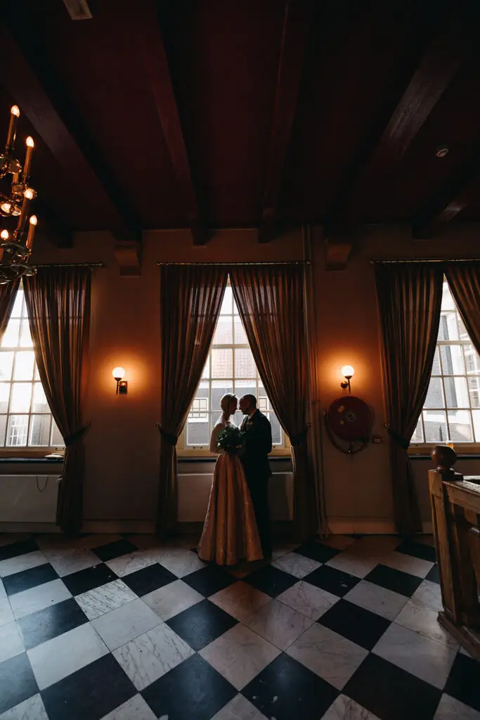 Couple standing together inside an elegant historic hall at West-Indisch Huis an intimate wedding elopement in Amsterdam