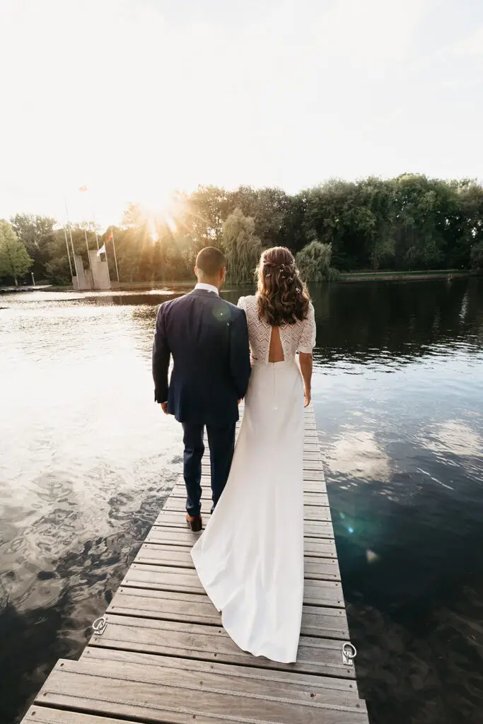 Couple walking on a wooden dock by the water during a sunset park elopement in Amsterdam