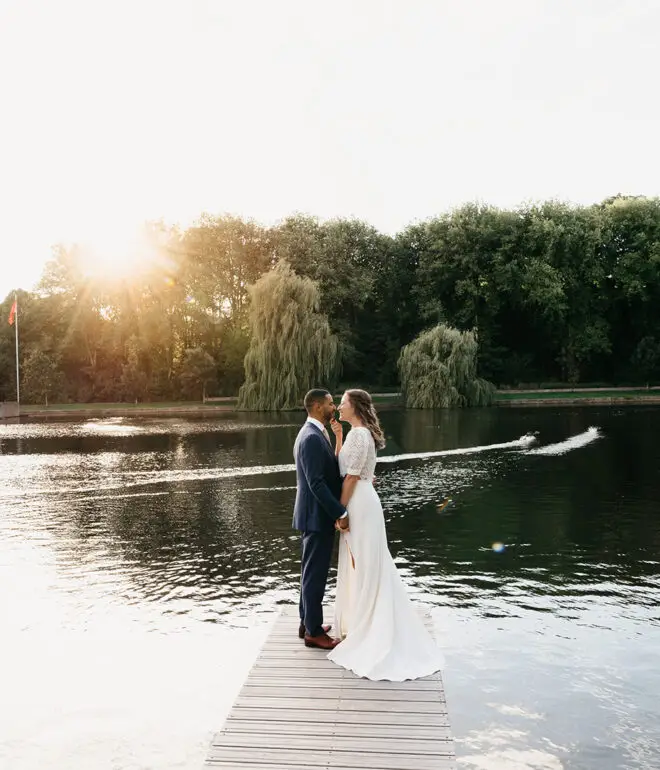 Couple standing on a wooden dock by the water during a peaceful park elopement in Amsterdam