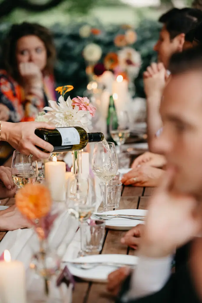 Guests enjoying an intimate wedding dinner and wine service during an Amsterdam elopement celebration
