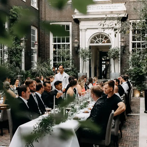 Guests enjoying an intimate wedding dinner in a historic Amsterdam courtyard venue