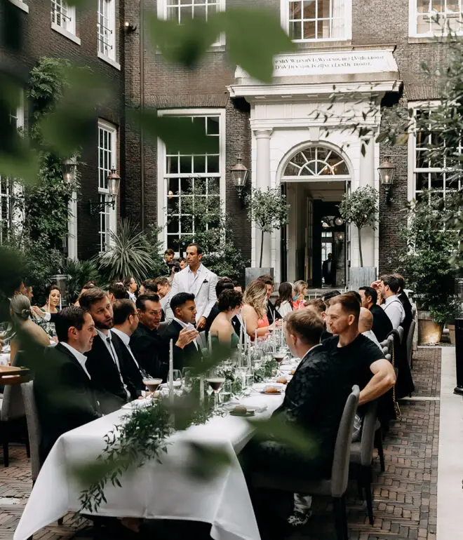 Guests enjoying an intimate wedding dinner in a historic Amsterdam courtyard venue