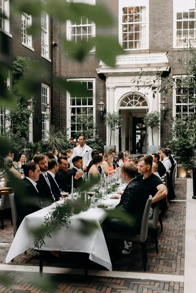 Guests enjoying an intimate wedding dinner in a historic Amsterdam courtyard venue