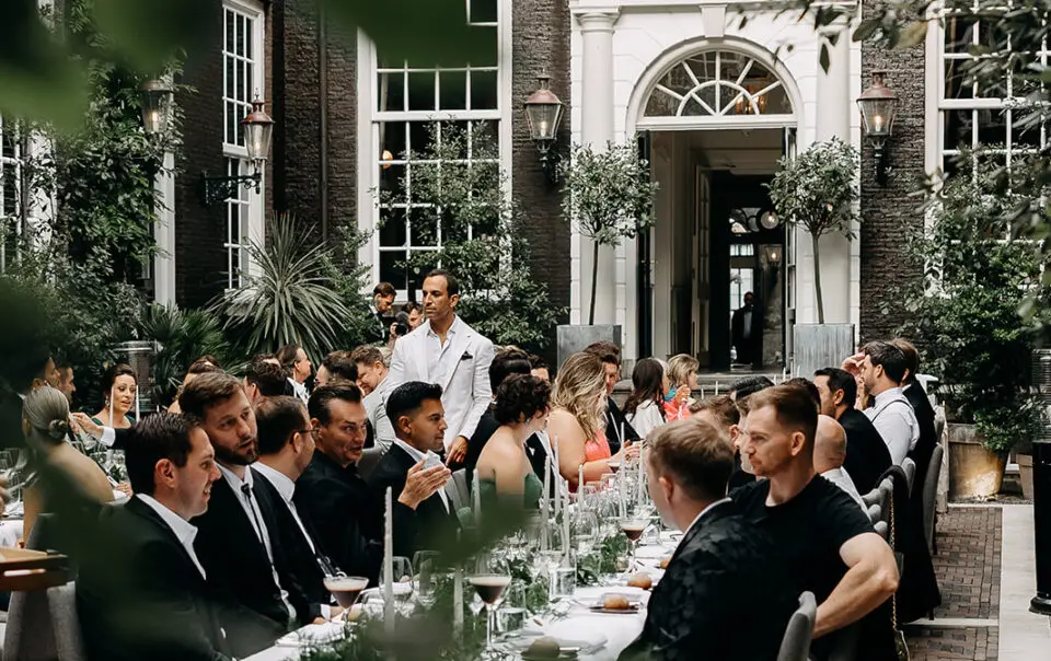 Guests enjoying an intimate wedding dinner in a historic Amsterdam courtyard venue