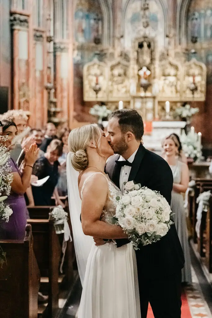 Couple kissing inside De Krijtberg church after ceremony during an intimate elopement in Amsterdam