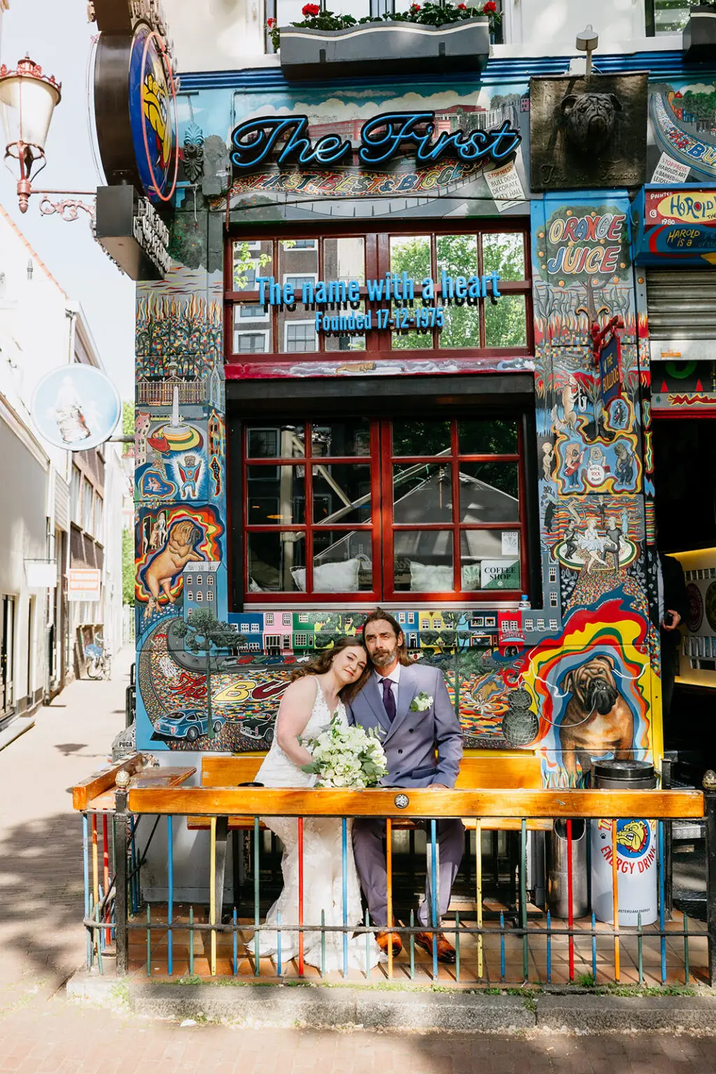 Couple sitting outside a colorful alternative venue in Amsterdam during an unconventional elopement
