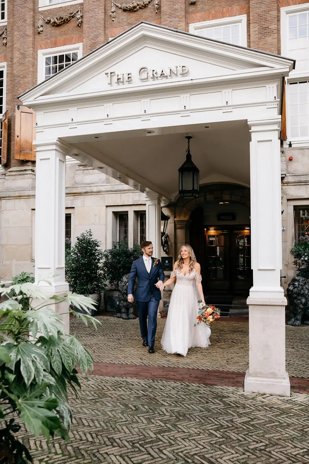 Couple leaving a luxury Amsterdam hotel after their intimate elopement ceremony