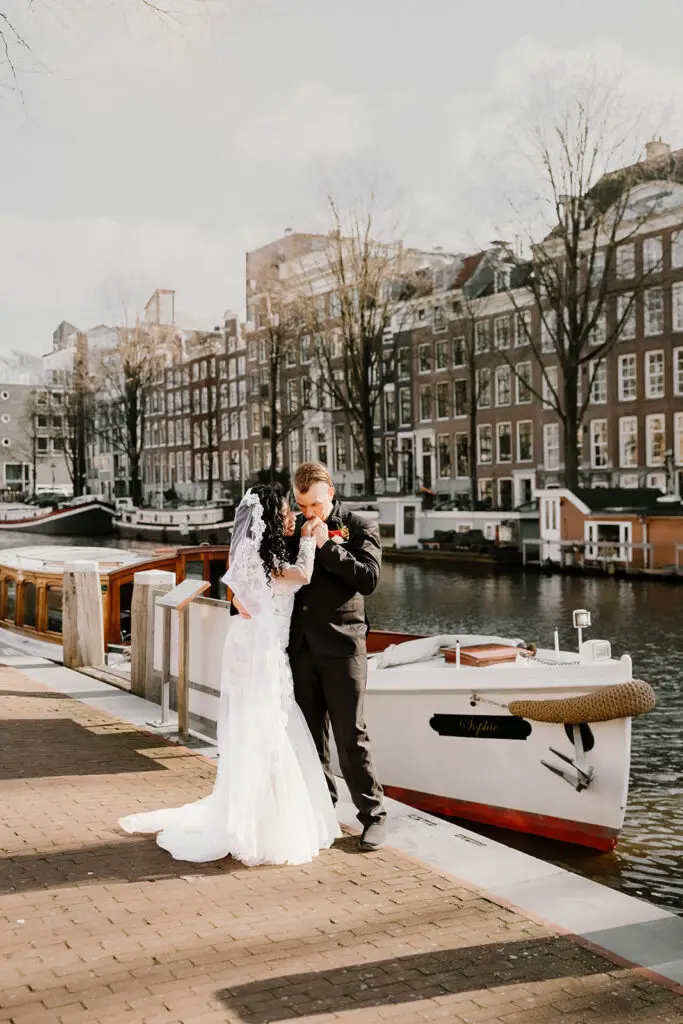 Couple standing beside a private canal boat during an intimate Amsterdam elopement