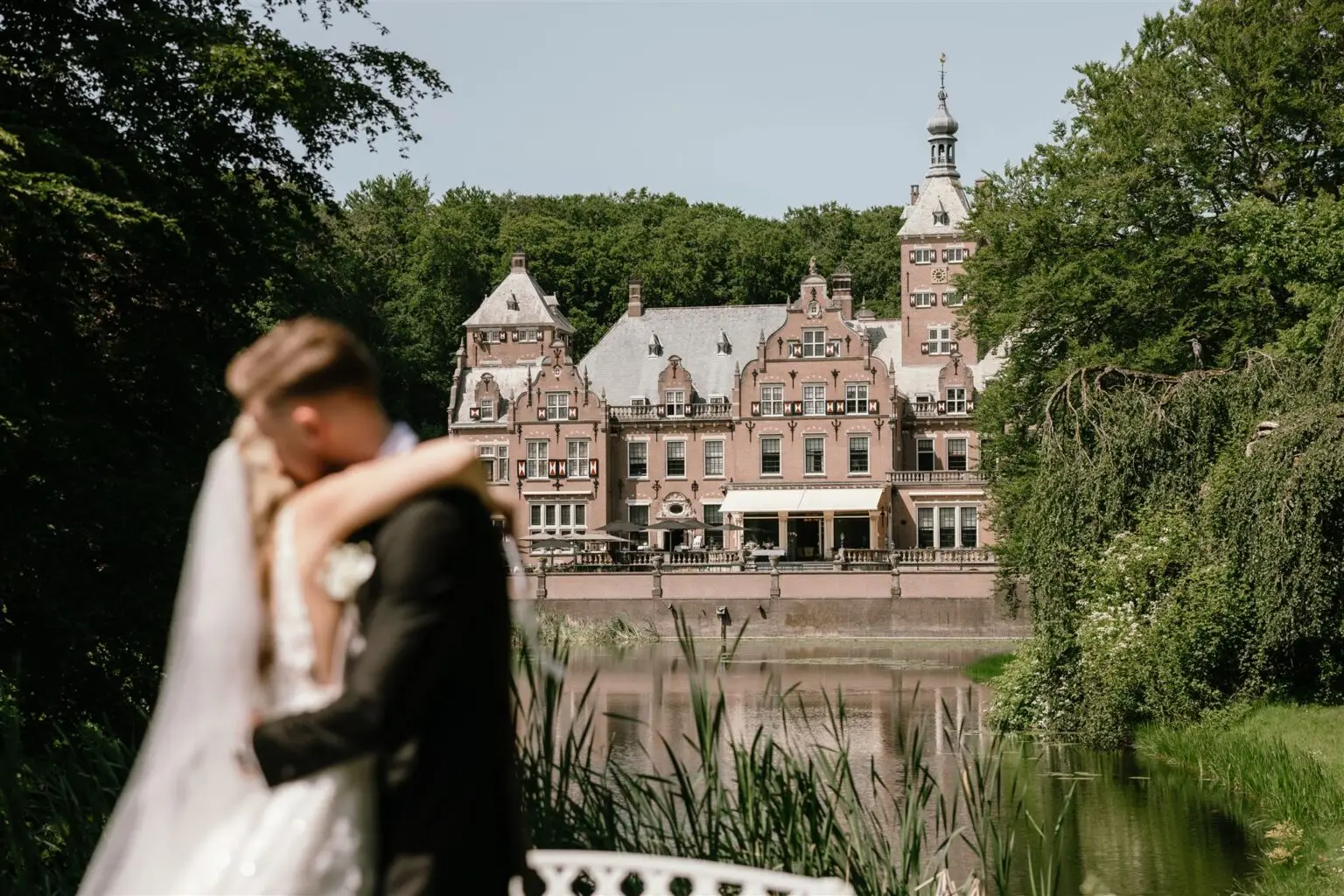 Couple embracing in front of Landgoed Duin & Kruidberg historic castle near Amsterdam during a romantic elopement
