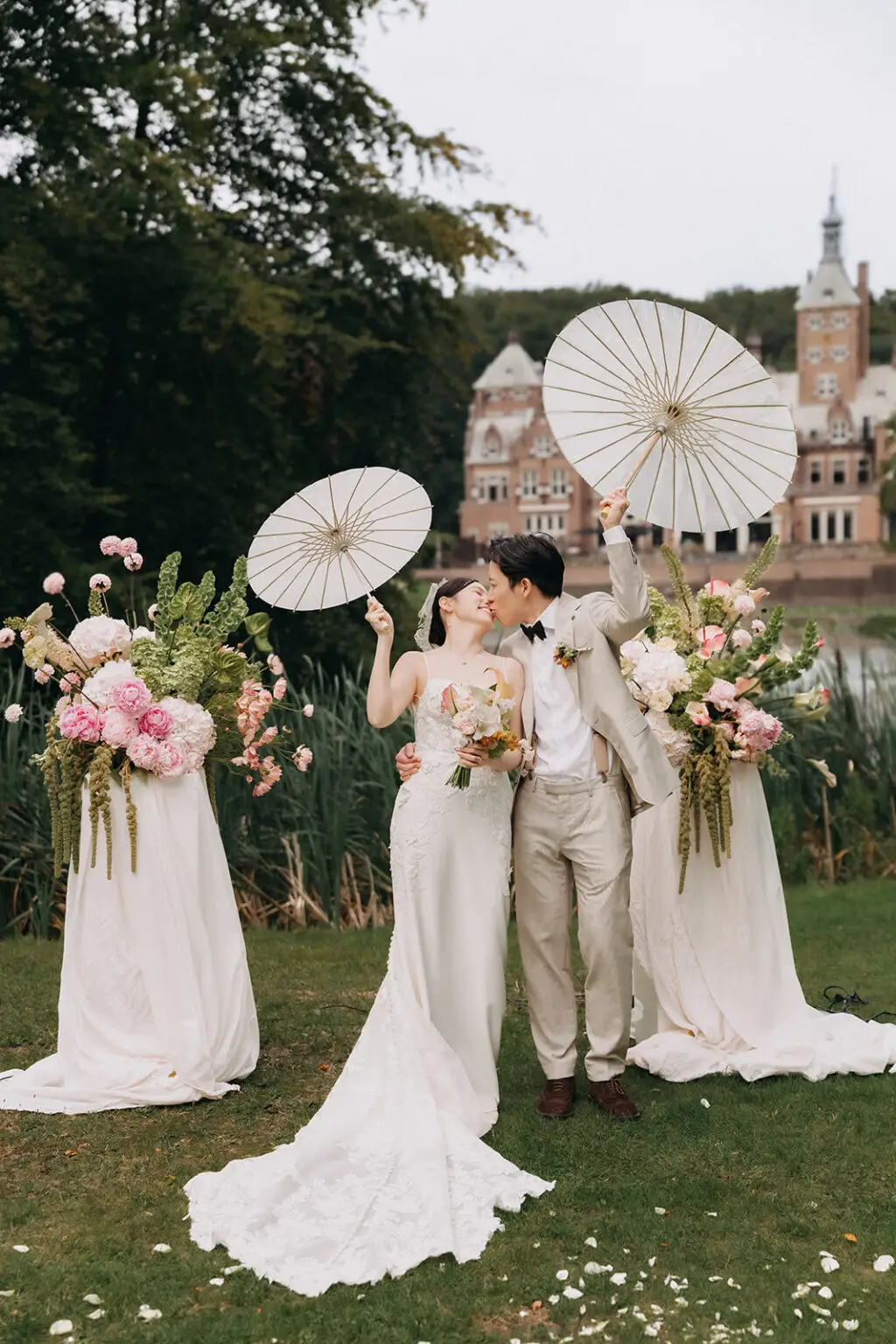 Couple celebrating in front of a castle near Amsterdam with floral setup during a romantic elopement wedding at Landgoed Duin & Kruidberg