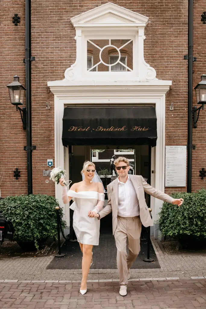Couple celebrating outside West-Indisch Huis Amsterdam after their elopement ceremony