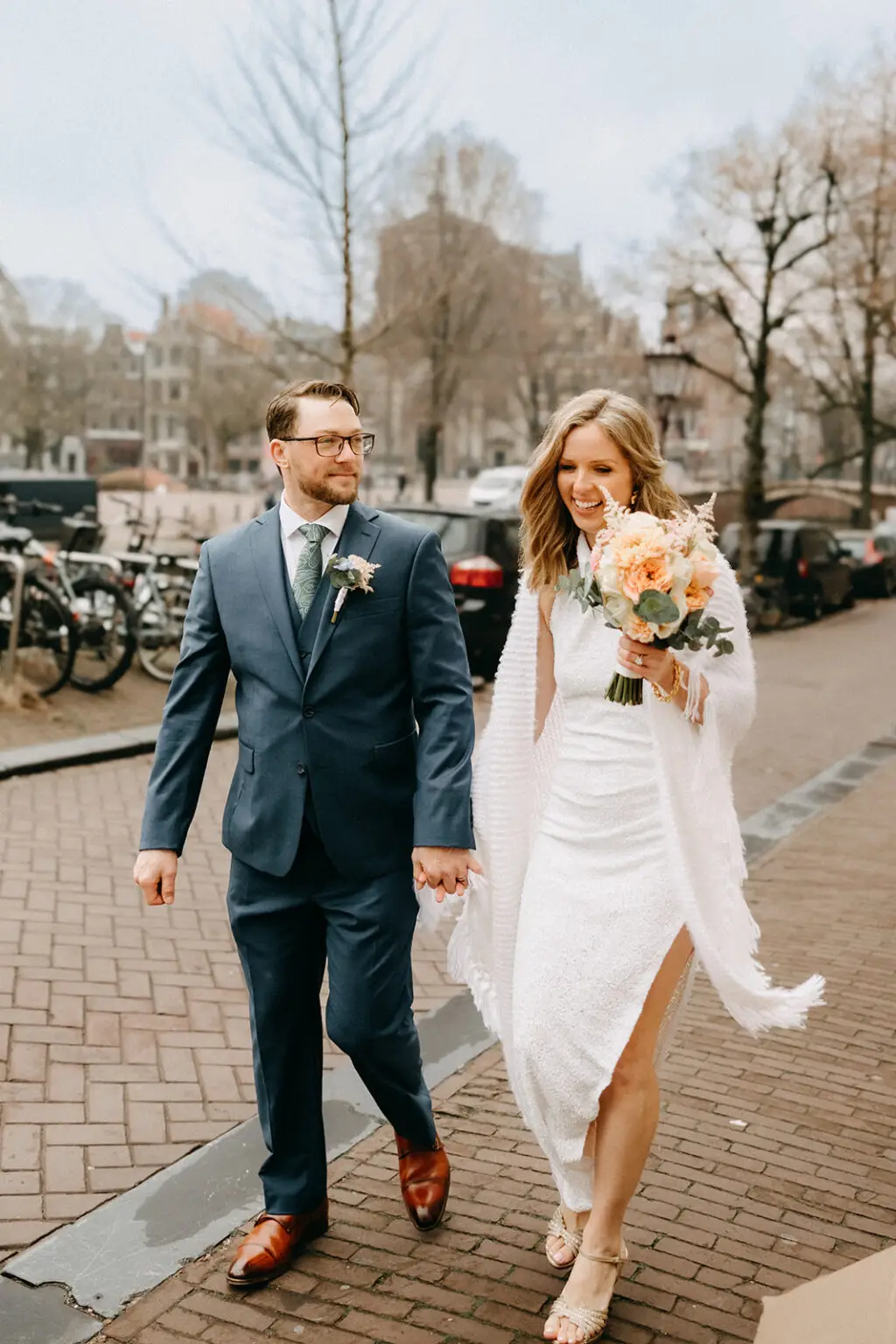 Couple walking through historic Amsterdam streets after their intimate elopement ceremony
