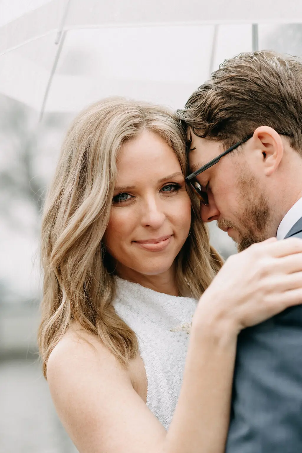Close-up portrait of Kristin and Logan embracing under an umbrella during their Amsterdam wedding photoshoot