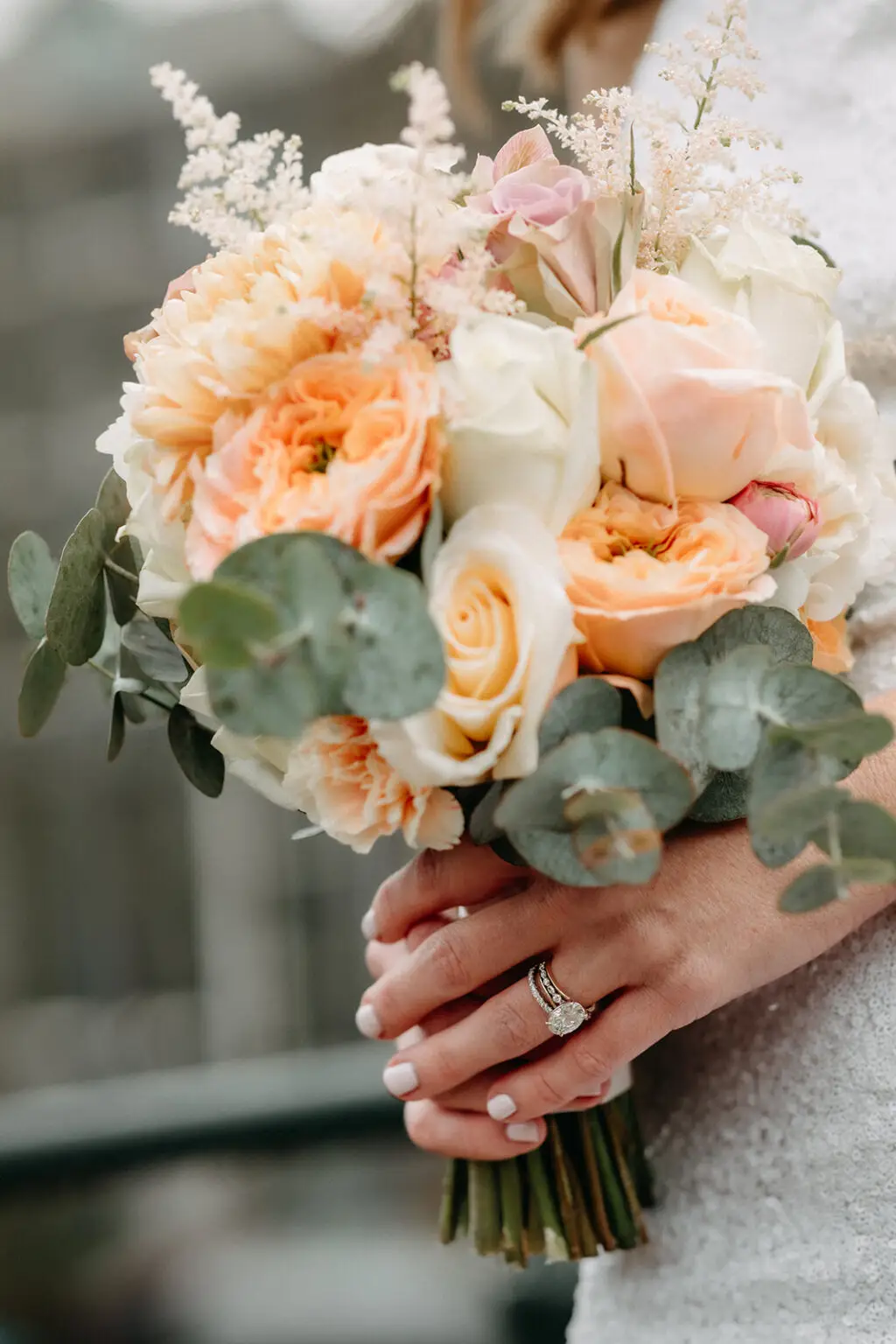 Close-up of a pastel bridal bouquet with roses and eucalyptus held during a wedding in Amsterdam
