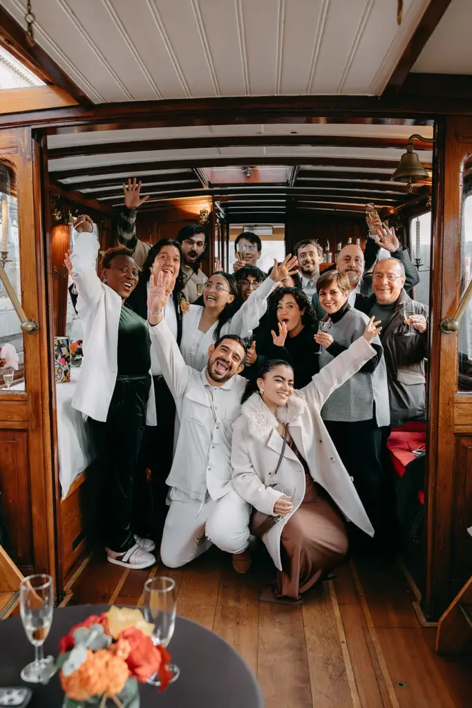 Friends and family celebrating aboard a private canal boat after an Amsterdam wedding ceremony