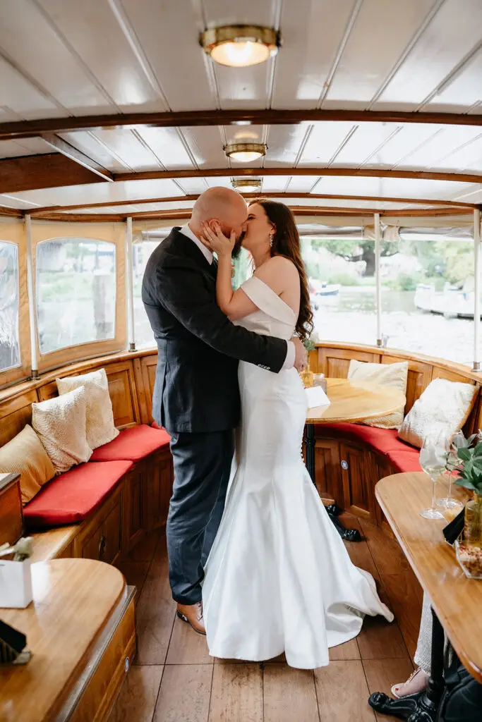 Bride and groom kissing aboard a private canal boat wedding in Amsterdam