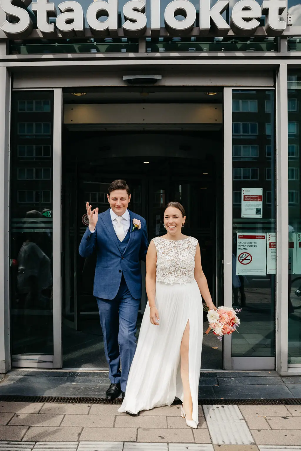 Newly married couple leaving Amsterdam city hall after their legal wedding ceremony