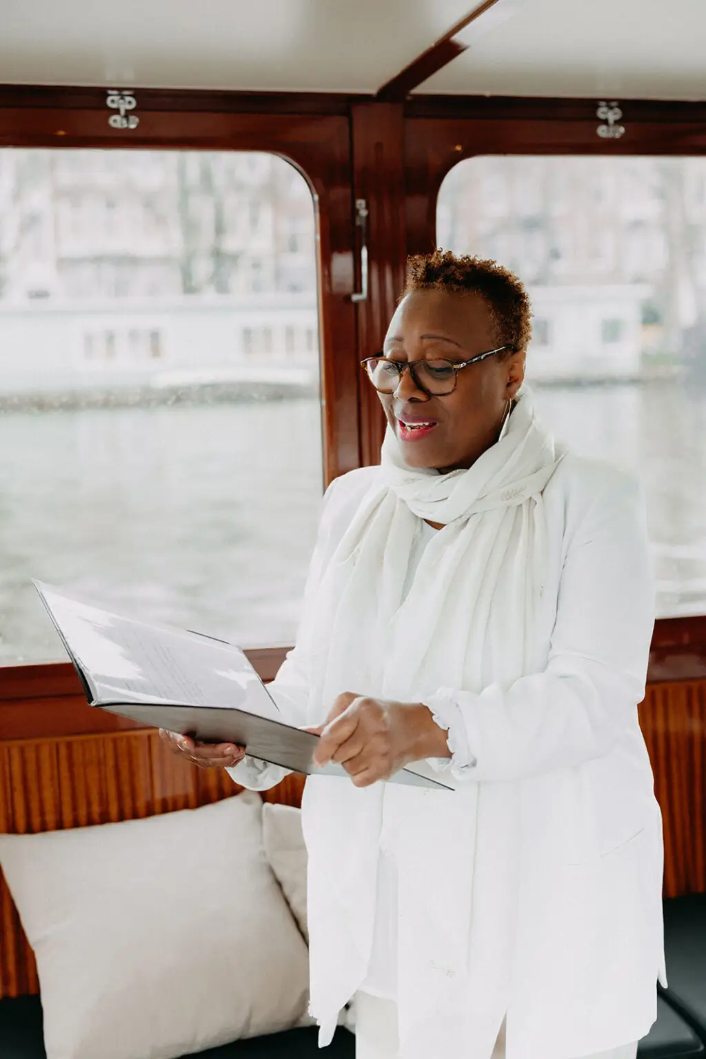 Wedding celebrant leading a symbolic ceremony aboard a private canal boat in Amsterdam