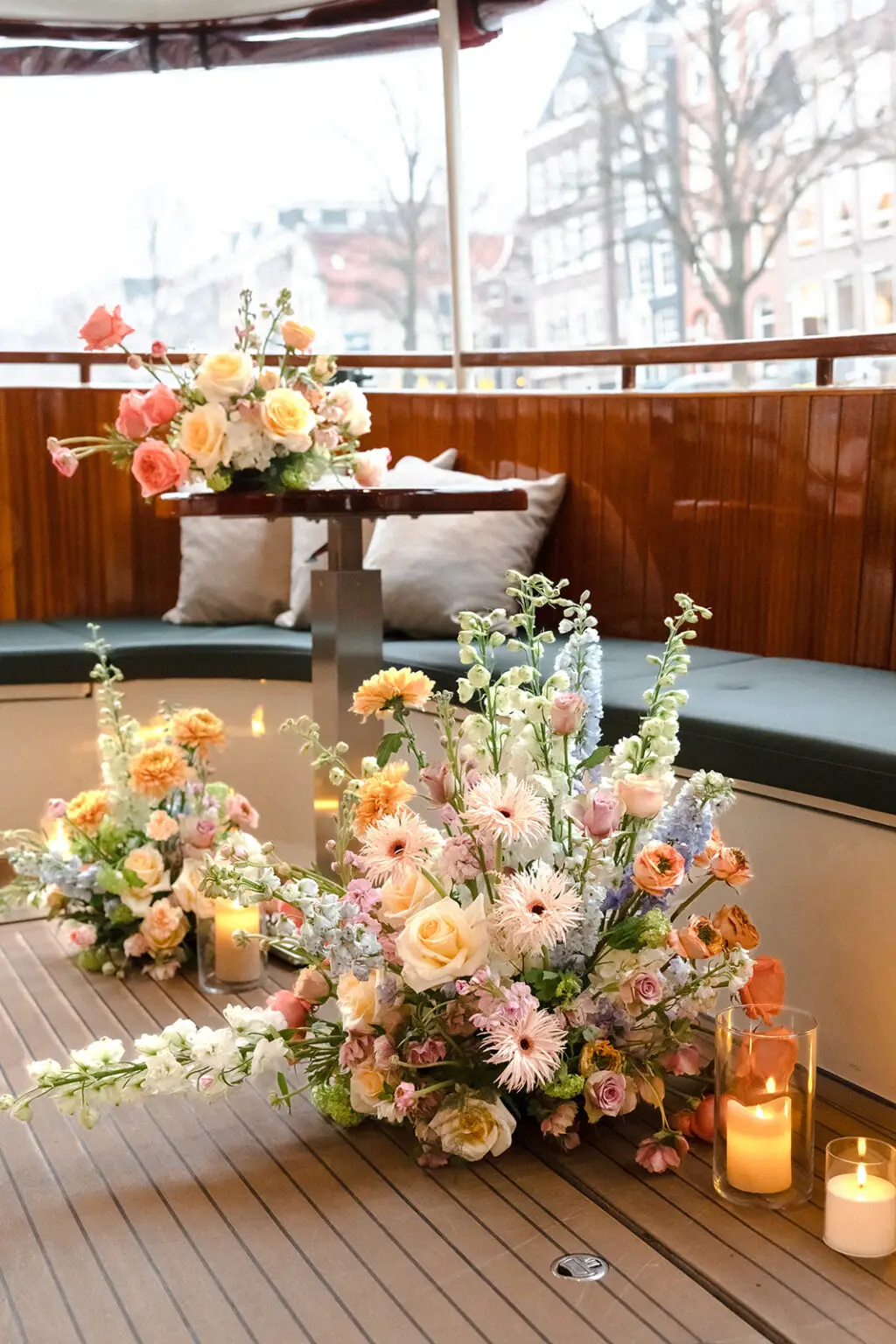Pastel wedding flowers and candles arranged inside a private canal boat ceremony space in Amsterdam