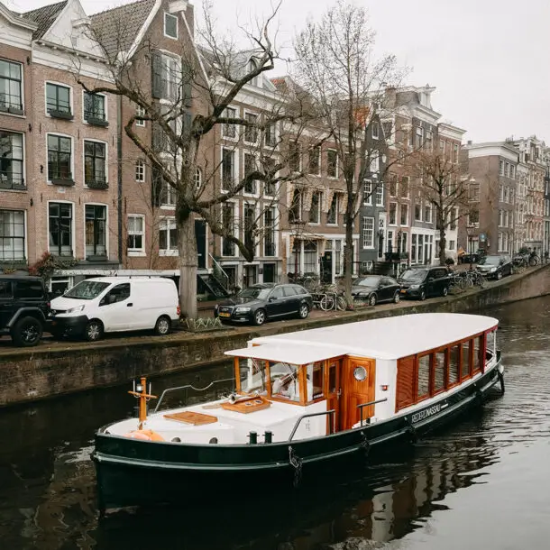 Private canal boat cruising through Amsterdam canals during a spring wedding day