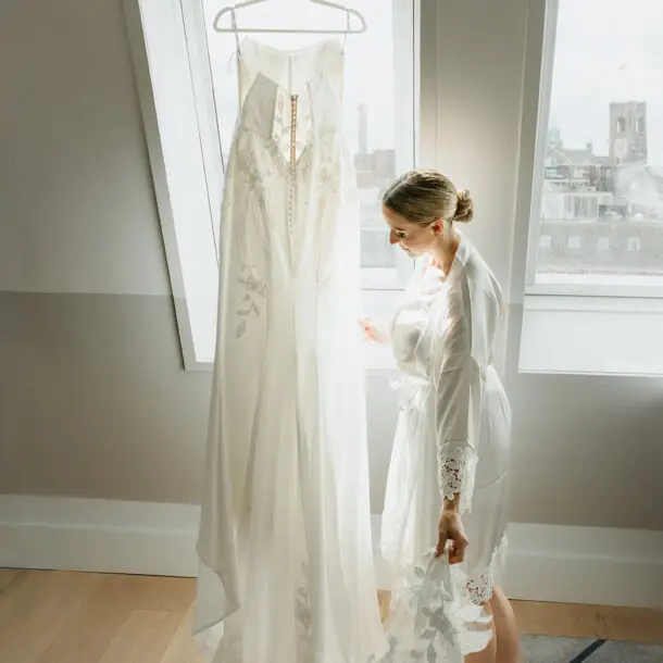 Bride admiring her wedding dress in a bright suite at Hotel De Witt before the Amsterdam wedding