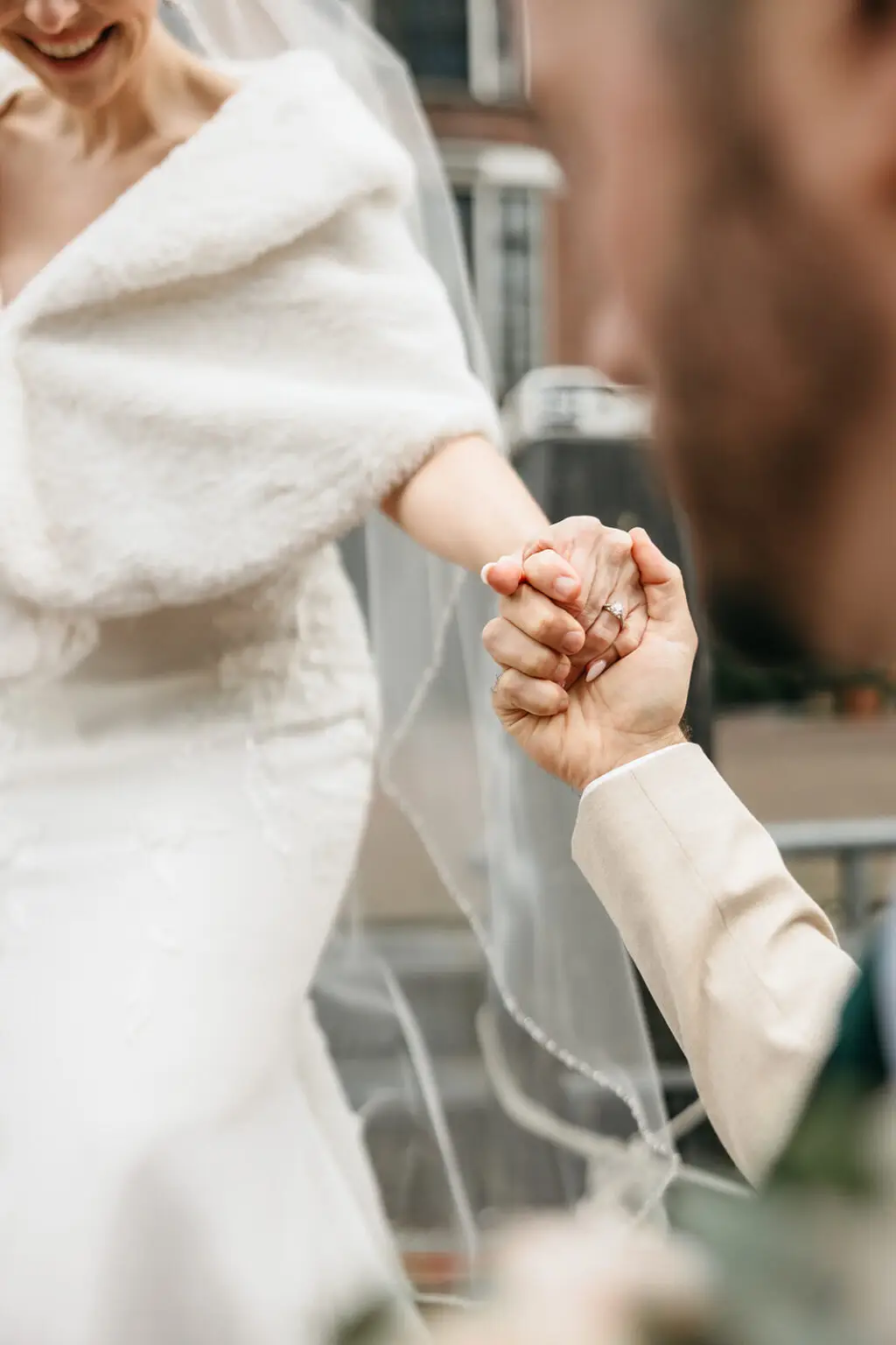Bride and groom holding hands while walking beside the Amsterdam canals before their boat wedding
