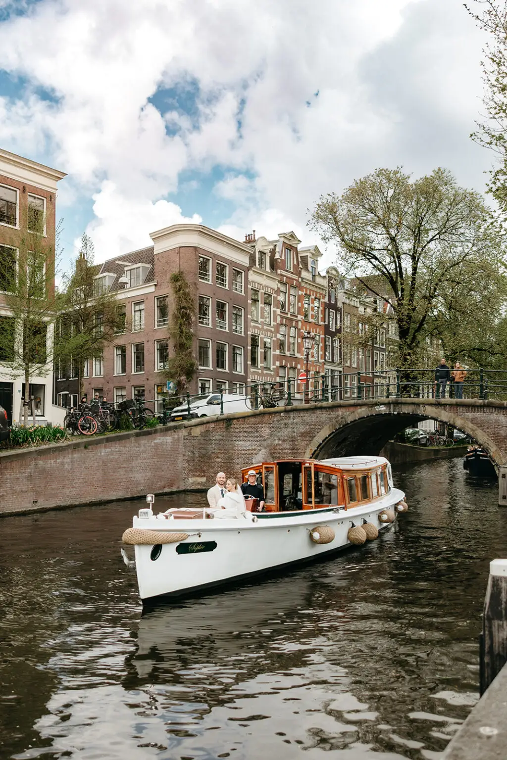 Wedding boat from Rederij de Nederlanden carrying the bride and groom through Reguliersgracht in Amsterdam during their canal wedding celebration.