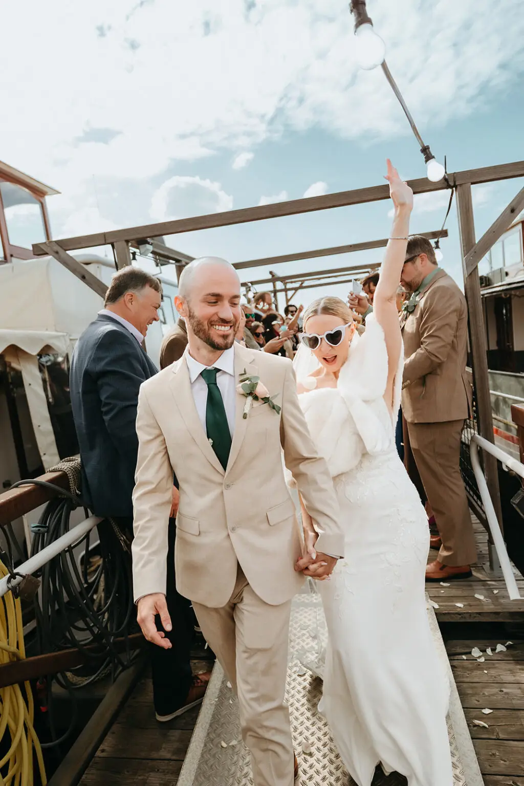 Bride celebrating with raised arms after the wedding ceremony on the deck of Het Wapen van Amsterdam