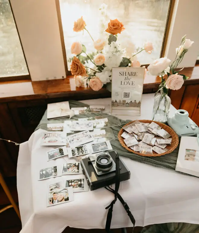 Wedding guestbook table with instant camera and printed photos during an Amsterdam destination wedding reception