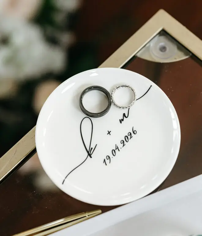 Wedding rings displayed on a personalised invitation with Amsterdam canal house illustration before the ceremony
