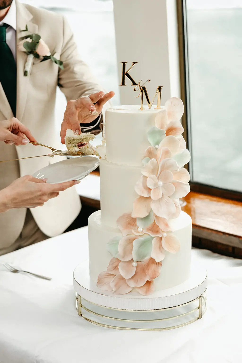 Bride and groom cutting their wedding cake aboard an Amsterdam canal boat during a destination wedding reception