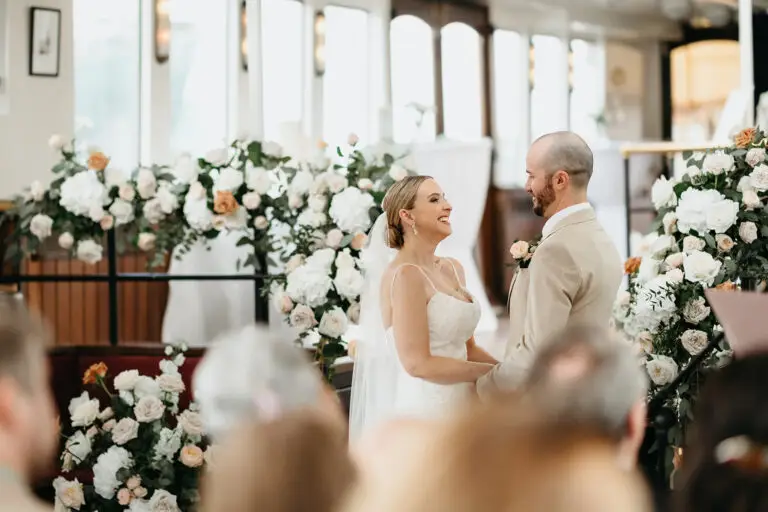 Bride and groom smiling together during their ceremony aboard Het Wapen van Amsterdam