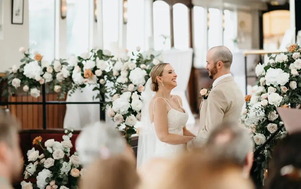 Bride and groom smiling together during their ceremony aboard Het Wapen van Amsterdam