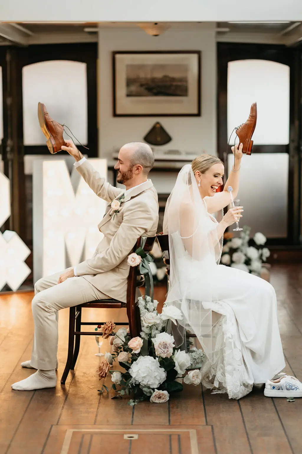 Bride and groom playing the wedding shoe game aboard an Amsterdam canal boat during a destination wedding reception